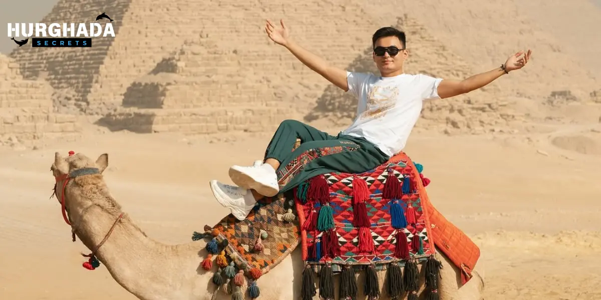 A man on a camel in front of the pyramids