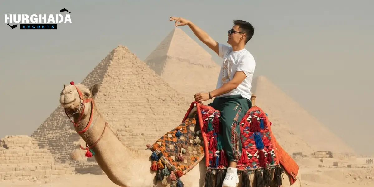 A man on a camel in front of the pyramids
