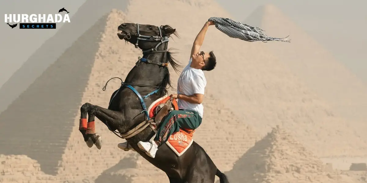 A man on a horse in front of the pyramids