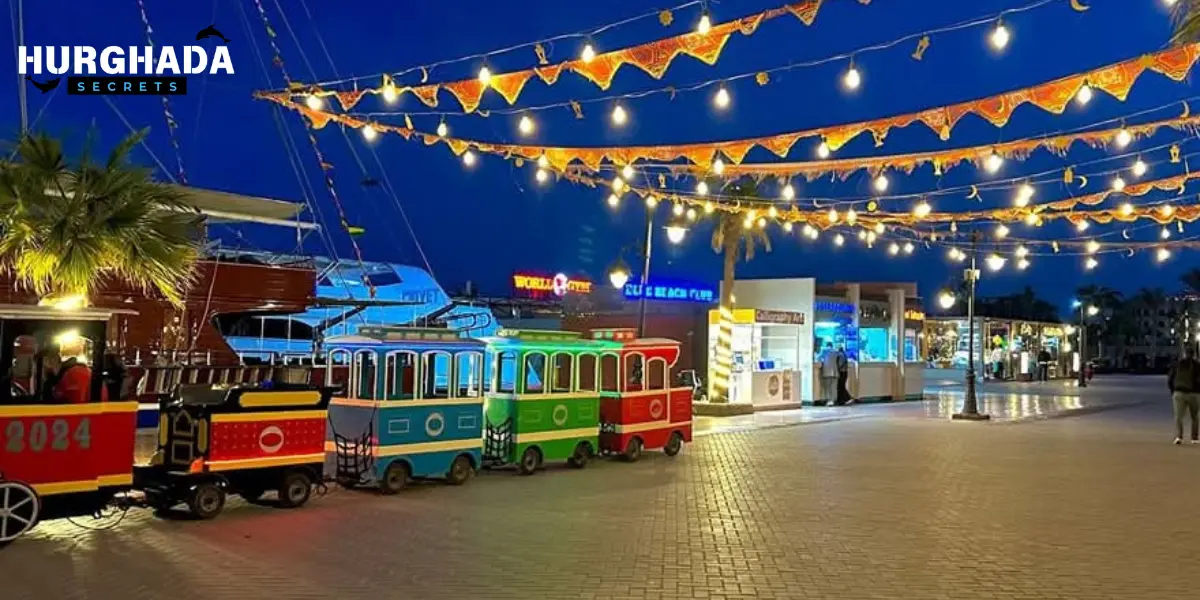 Colorful tourist train under festive lights on a promenade in Hurghada